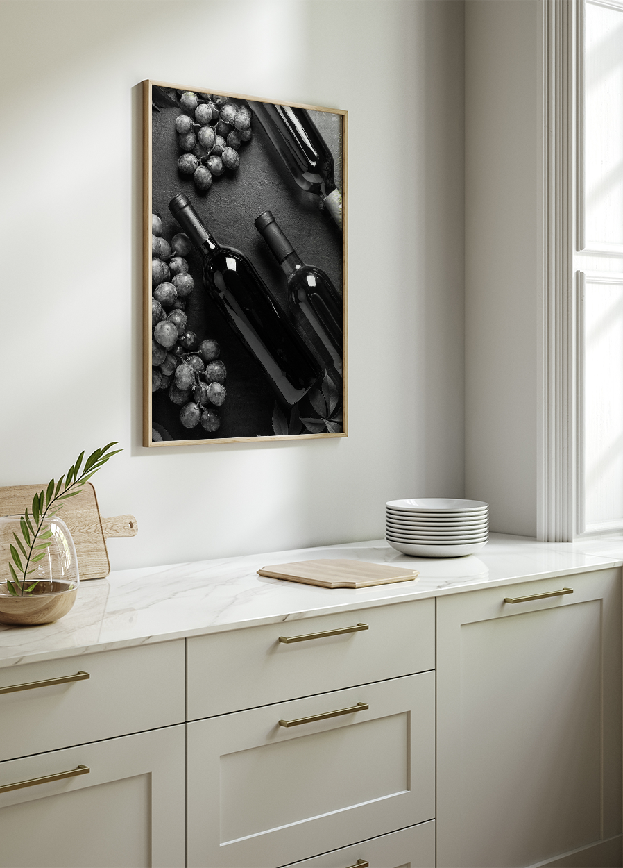 a black and white photo of wine bottles and grapes