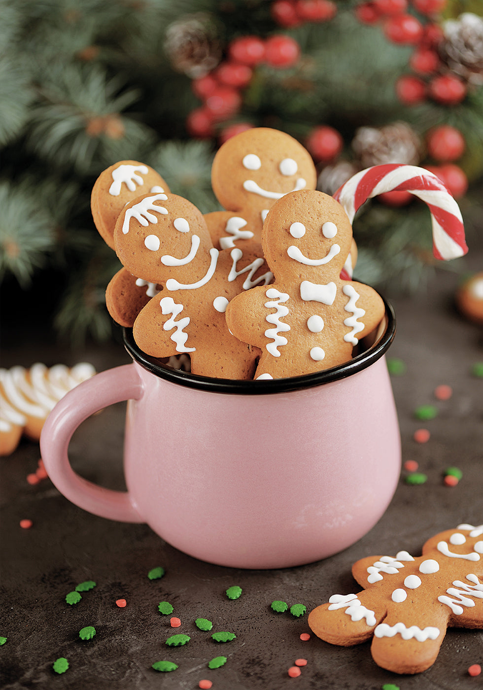 a pink mug filled with cookies and candy canes