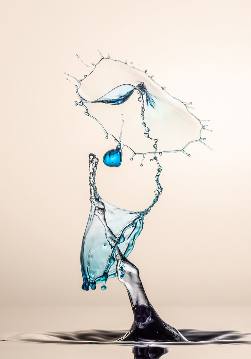 a dynamic water splash, with a blue object suspended in mid-air and a large splash of water cascading down, creating a sense of movement and energy.